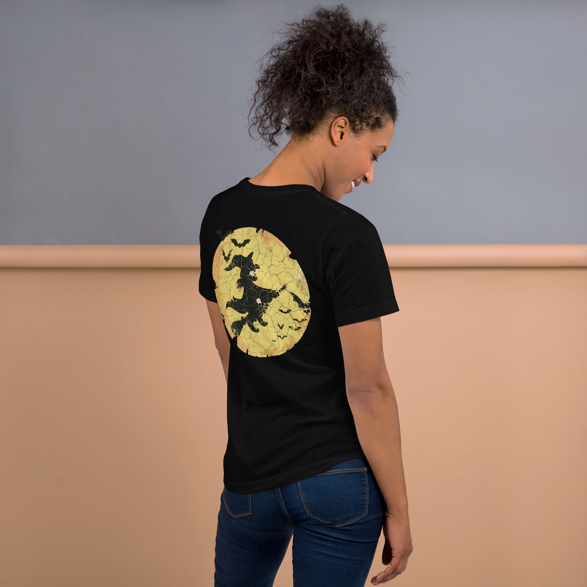 Mujer con camiseta negra vintage de bruja sobre luna cuarteada y murciélagos