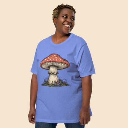 Hombre sonriendo con camiseta azul suave y estampado de seta del bosque retro.