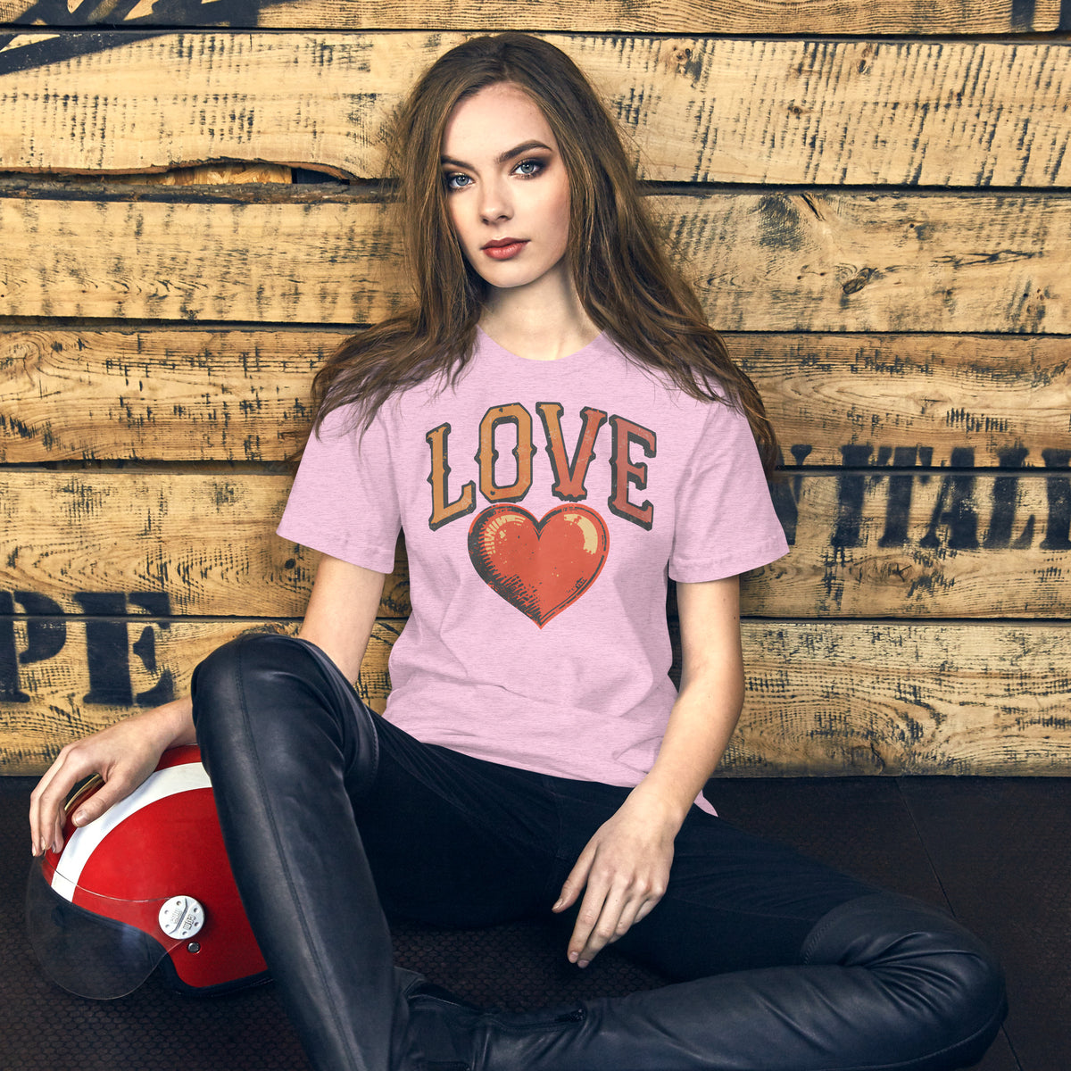 Persona sentada con camiseta rosa de estilo retro Love y diseño de corazón vintage.