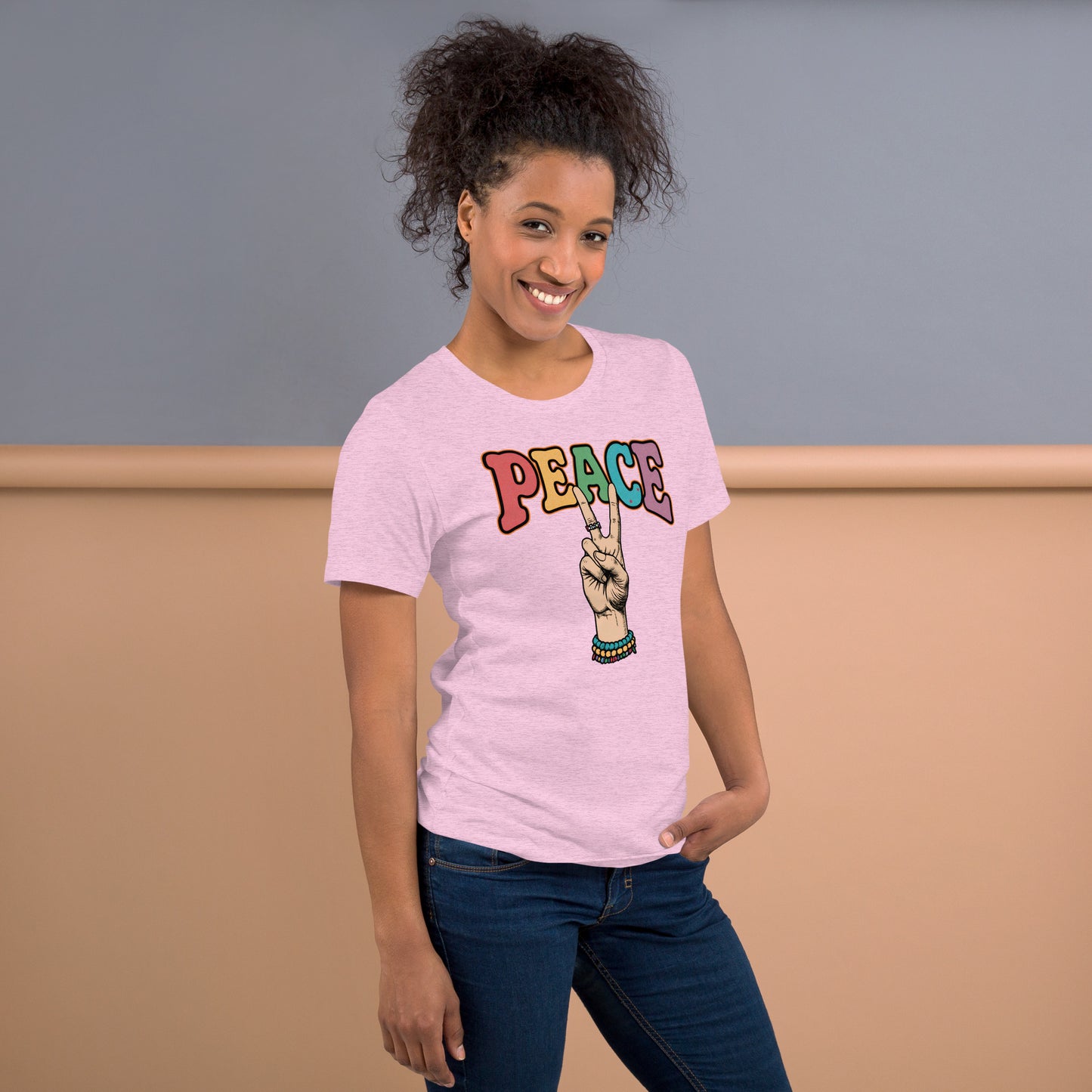 Mujer vistiendo camiseta rosa con diseño Peace multicolor y símbolo de la paz estilo retro