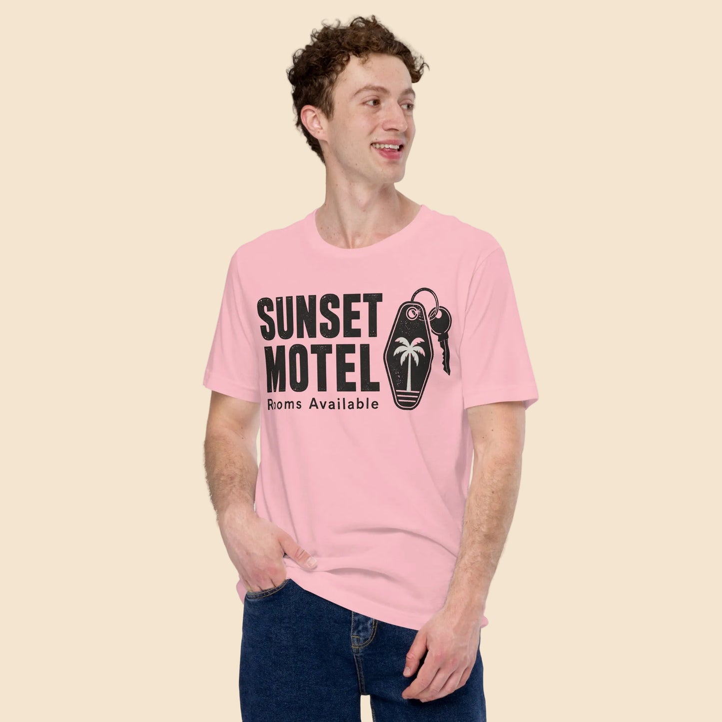 Hombre luciendo una camiseta rosa pastel con estampado vintage Sunset Motel ideal para un look de verano retro de estilo indie.