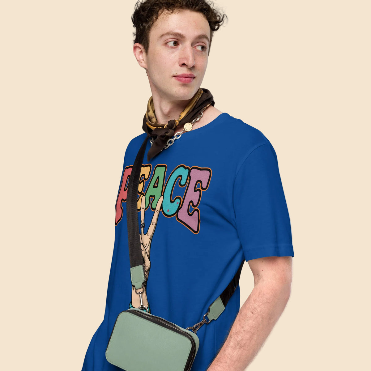 Hombre vistiendo camiseta azul con gráfico Peace multicolor de inspiración vintage y bohemia