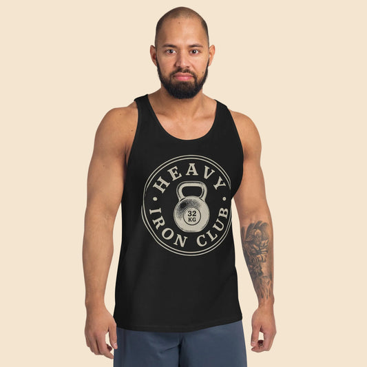 Hombre vistiendo camiseta de tirantes negra con diseño frontal de herencia atlética e insignia de levantamiento de peso.