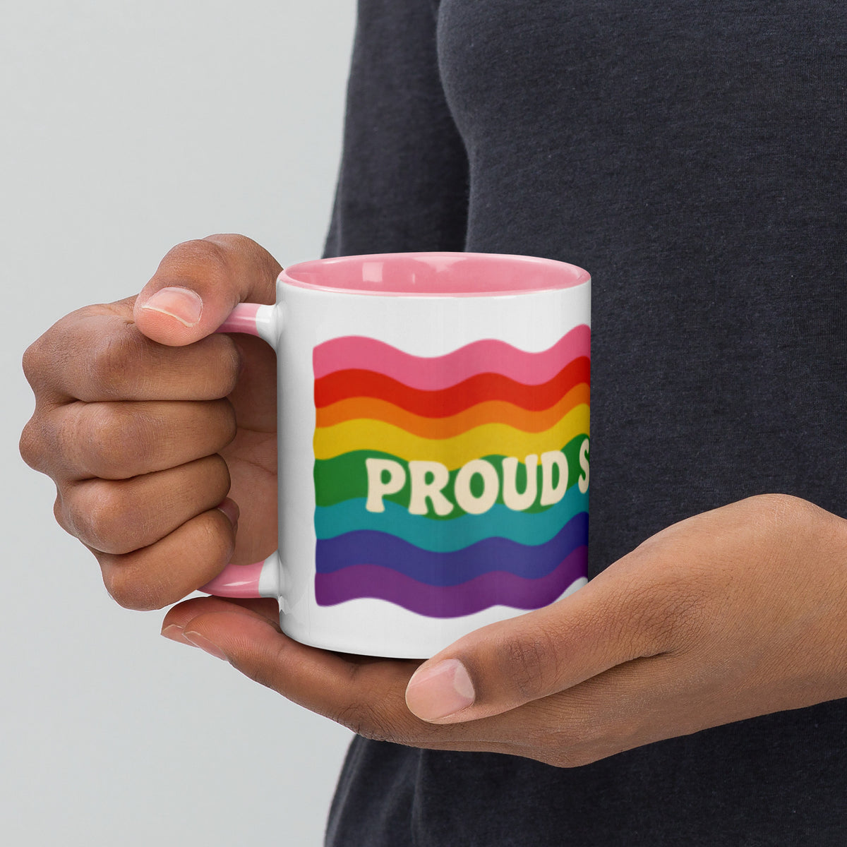 Persona sosteniendo taza Pride con diseño vintage de ondas arcoíris y mensaje Proud Since 1978.