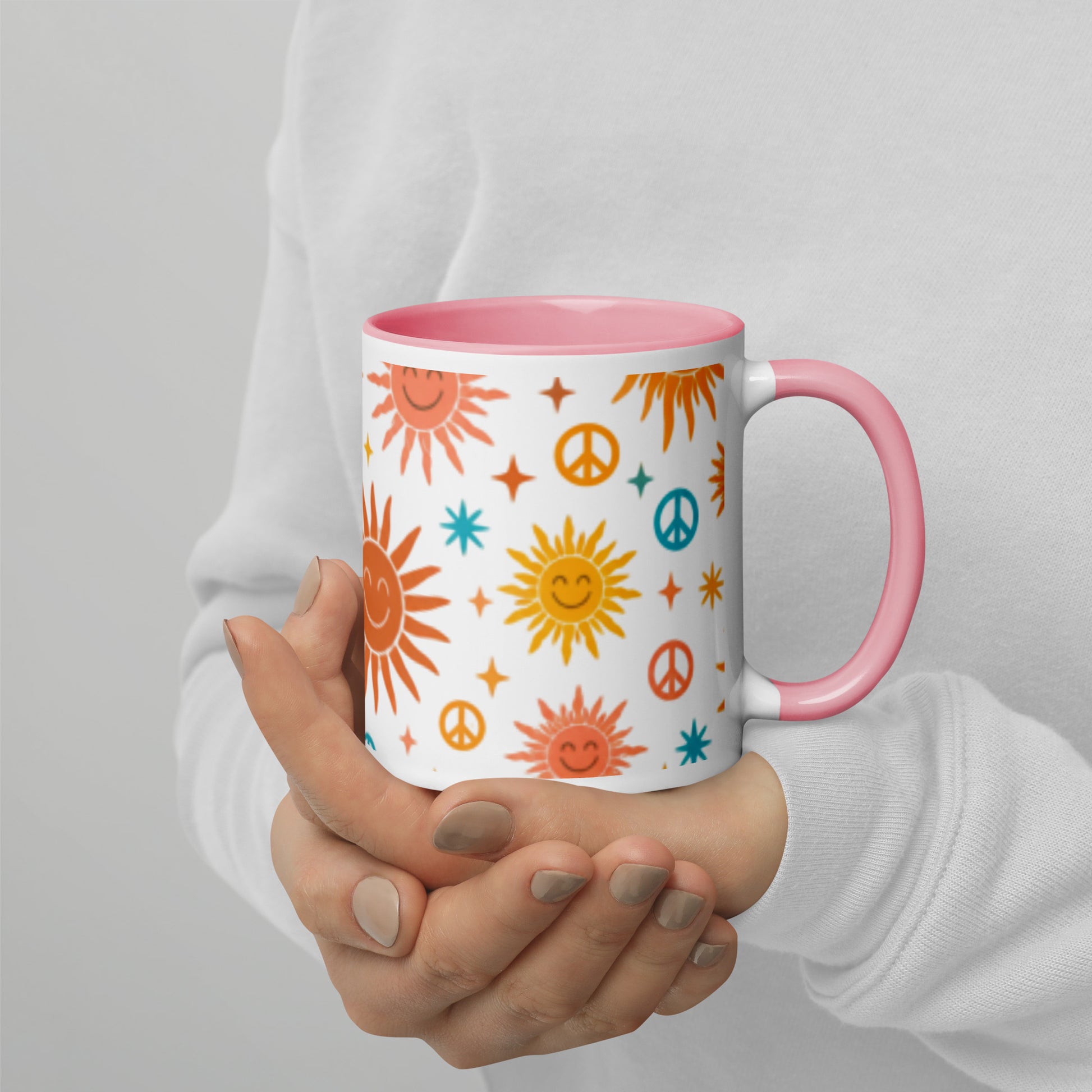 Persona sosteniendo una taza de cerámica retro con estampado de soles sonrientes inspirado en los años 70.