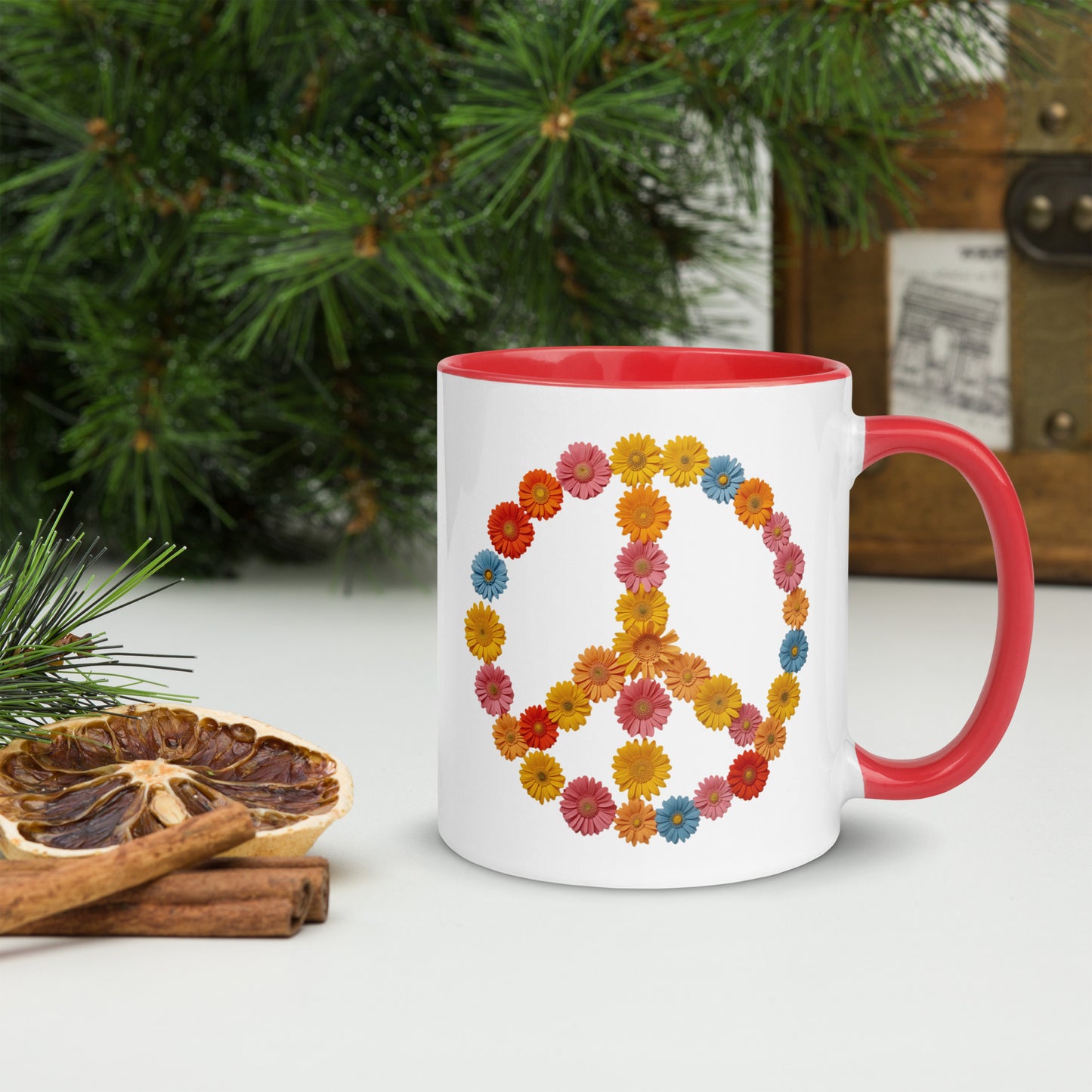 Taza con interior y asa de color rojo y símbolo de la paz botánico, situada sobre una superficie de madera con elementos decorativos.