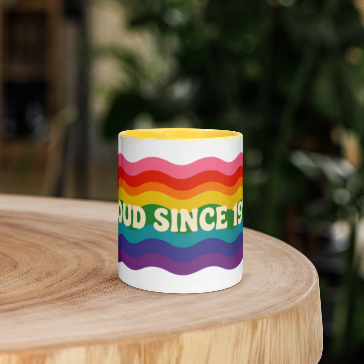 Taza de cerámica con interior amarillo y diseño Pride retro sobre fondo de madera con estética vintage.