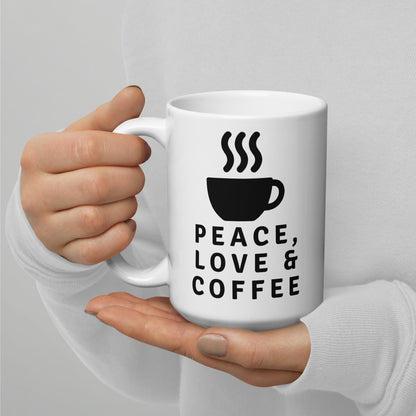 Mano sujetando taza de café blanca con ilustración negra de taza humeante y mensaje Peace Love Coffee.